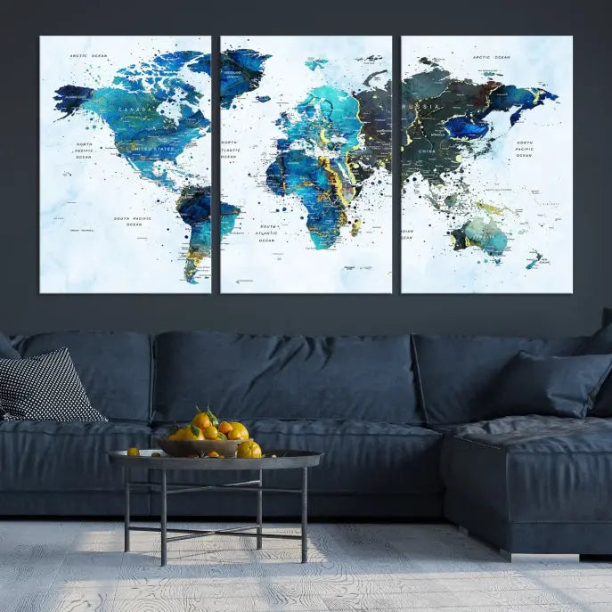 A Watercolor World Map Wall Art Canvas Print, arranged as a gallery-wrapped triptych in soothing blue and green tones, is displayed prominently.