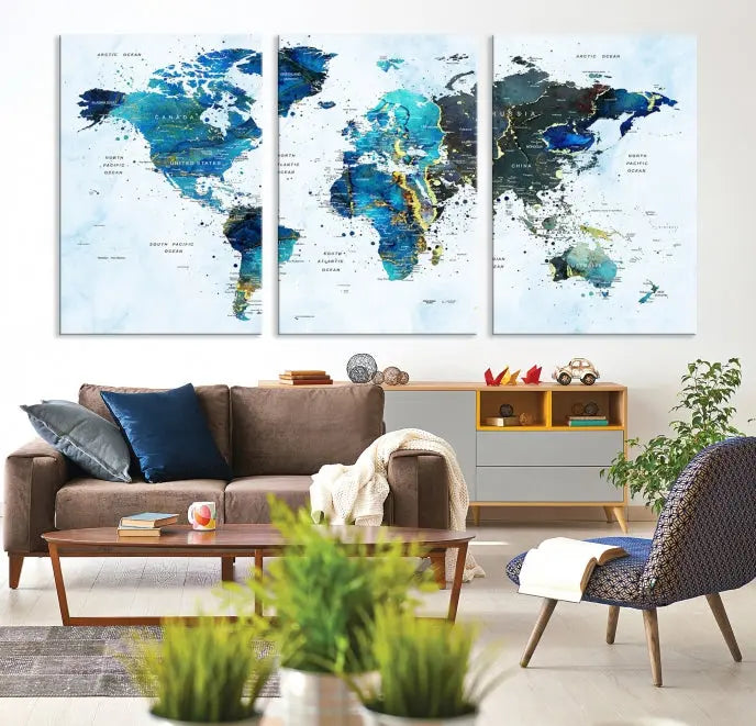 A Watercolor World Map Wall Art Canvas Print, arranged as a gallery-wrapped triptych in soothing blue and green tones, is displayed prominently.