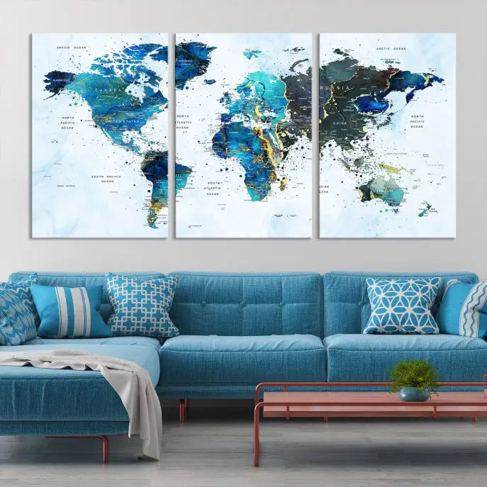 A Watercolor World Map Wall Art Canvas Print, arranged as a gallery-wrapped triptych in soothing blue and green tones, is displayed prominently.