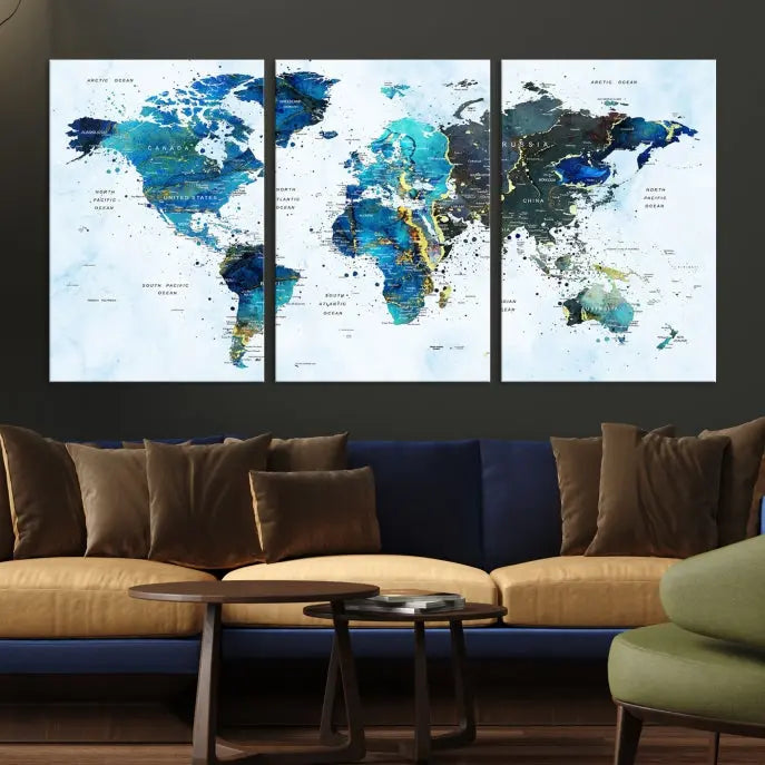 A Watercolor World Map Wall Art Canvas Print, arranged as a gallery-wrapped triptych in soothing blue and green tones, is displayed prominently.