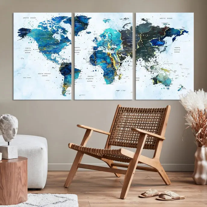 A Watercolor World Map Wall Art Canvas Print, arranged as a gallery-wrapped triptych in soothing blue and green tones, is displayed prominently.