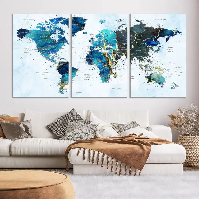 A Watercolor World Map Wall Art Canvas Print, arranged as a gallery-wrapped triptych in soothing blue and green tones, is displayed prominently.