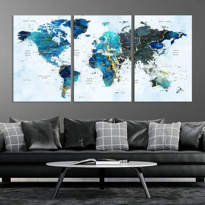 A Watercolor World Map Wall Art Canvas Print, arranged as a gallery-wrapped triptych in soothing blue and green tones, is displayed prominently.