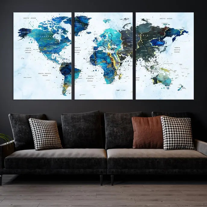 A Watercolor World Map Wall Art Canvas Print, arranged as a gallery-wrapped triptych in soothing blue and green tones, is displayed prominently.