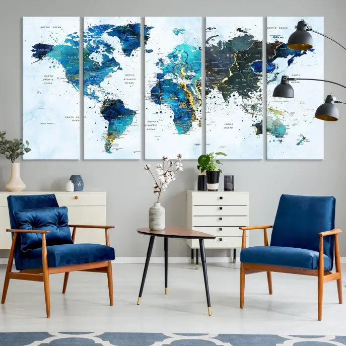 A Watercolor World Map Wall Art Canvas Print, arranged as a gallery-wrapped triptych in soothing blue and green tones, is displayed prominently.