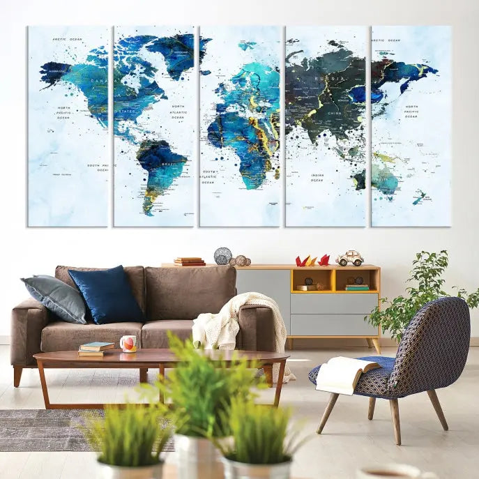 A Watercolor World Map Wall Art Canvas Print, arranged as a gallery-wrapped triptych in soothing blue and green tones, is displayed prominently.