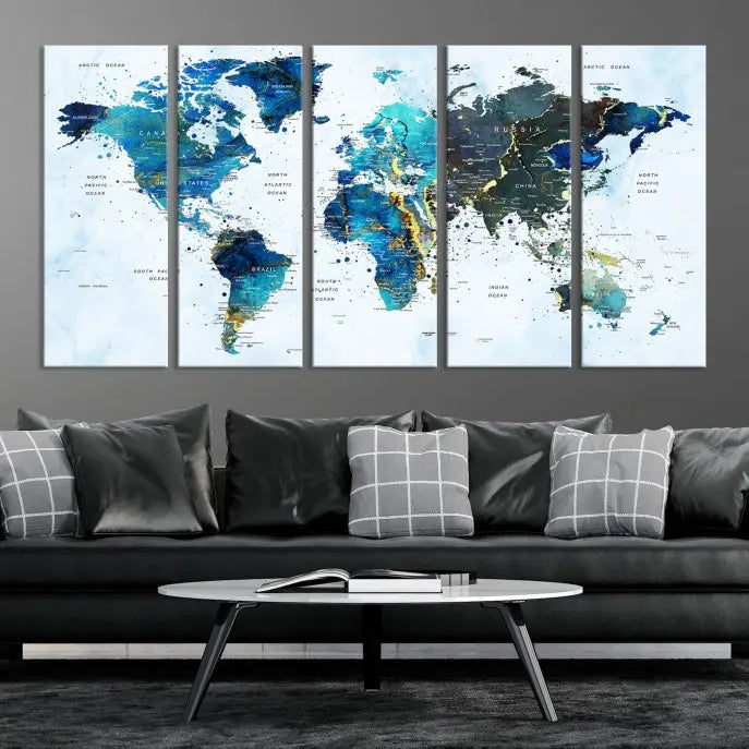 A Watercolor World Map Wall Art Canvas Print, arranged as a gallery-wrapped triptych in soothing blue and green tones, is displayed prominently.