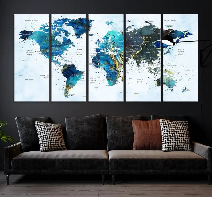 A Watercolor World Map Wall Art Canvas Print, arranged as a gallery-wrapped triptych in soothing blue and green tones, is displayed prominently.