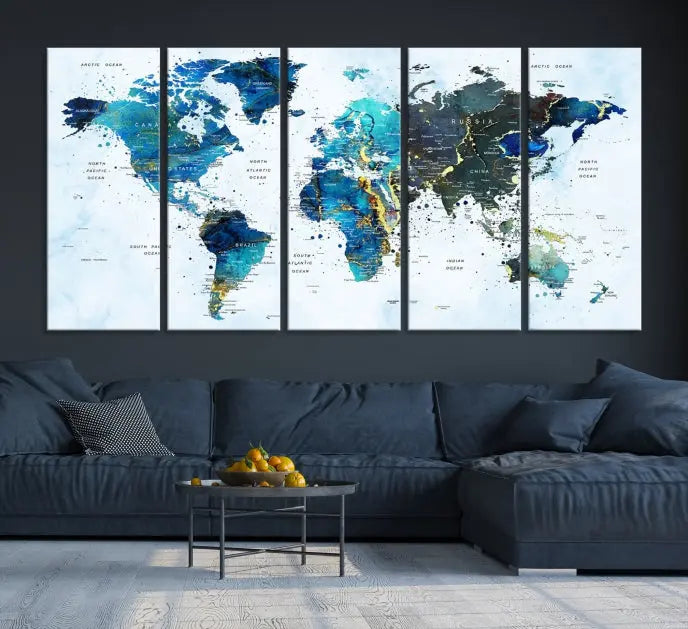 A Watercolor World Map Wall Art Canvas Print, arranged as a gallery-wrapped triptych in soothing blue and green tones, is displayed prominently.