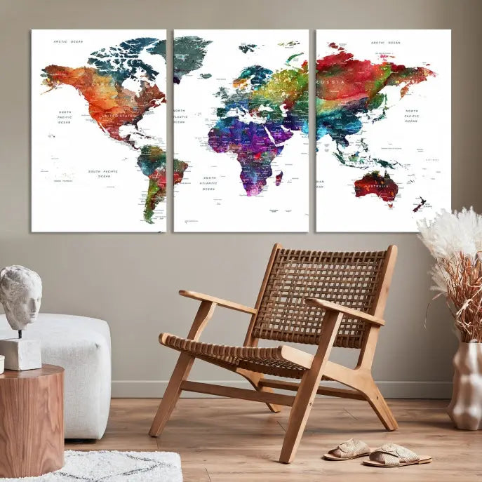 The "Watercolor World Map Wall Art Canvas Print," crafted by professional artisans, features three vibrant panels on museum-quality canvas, adorning the wall in a chic, minimalist room.