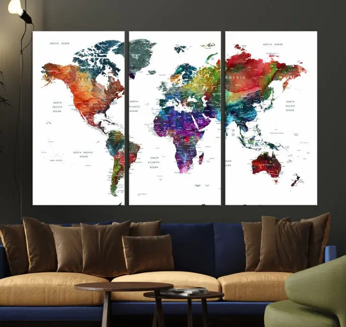 The "Watercolor World Map Wall Art Canvas Print," crafted by professional artisans, features three vibrant panels on museum-quality canvas, adorning the wall in a chic, minimalist room.