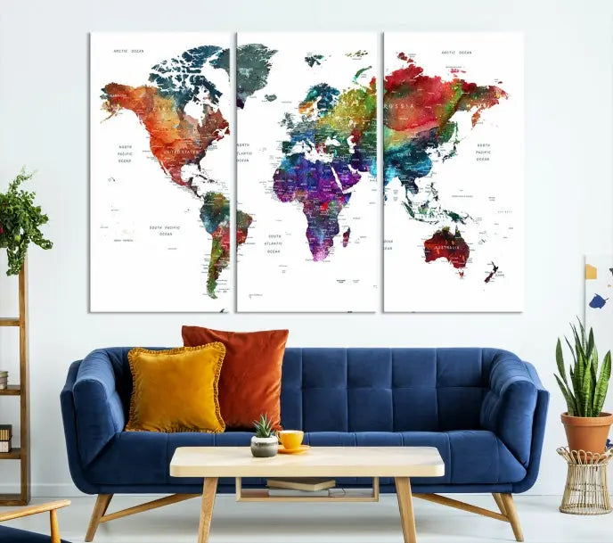 The "Watercolor World Map Wall Art Canvas Print," crafted by professional artisans, features three vibrant panels on museum-quality canvas, adorning the wall in a chic, minimalist room.