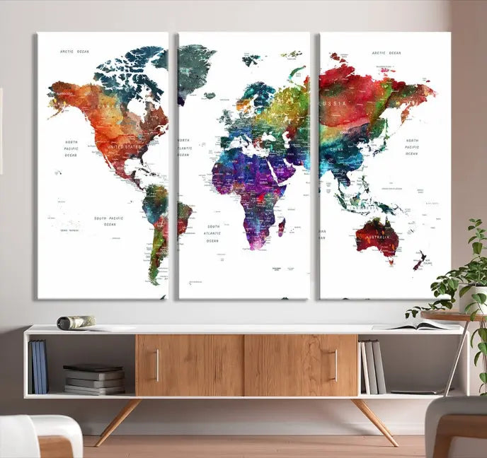 The "Watercolor World Map Wall Art Canvas Print," crafted by professional artisans, features three vibrant panels on museum-quality canvas, adorning the wall in a chic, minimalist room.