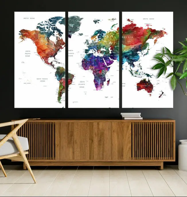 The "Watercolor World Map Wall Art Canvas Print," crafted by professional artisans, features three vibrant panels on museum-quality canvas, adorning the wall in a chic, minimalist room.