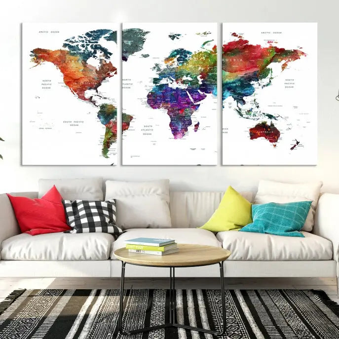 The "Watercolor World Map Wall Art Canvas Print," crafted by professional artisans, features three vibrant panels on museum-quality canvas, adorning the wall in a chic, minimalist room.