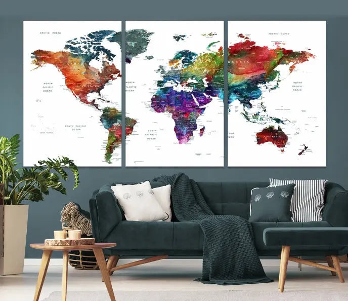 The "Watercolor World Map Wall Art Canvas Print," crafted by professional artisans, features three vibrant panels on museum-quality canvas, adorning the wall in a chic, minimalist room.