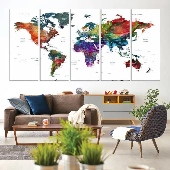 The "Watercolor World Map Wall Art Canvas Print," crafted by professional artisans, features three vibrant panels on museum-quality canvas, adorning the wall in a chic, minimalist room.