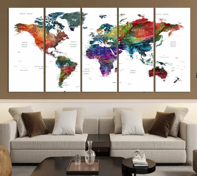 The "Watercolor World Map Wall Art Canvas Print," crafted by professional artisans, features three vibrant panels on museum-quality canvas, adorning the wall in a chic, minimalist room.