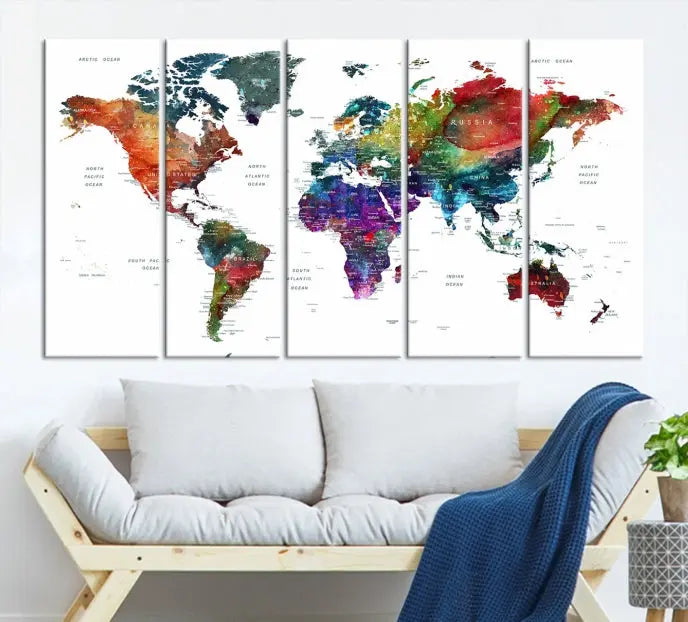 The "Watercolor World Map Wall Art Canvas Print," crafted by professional artisans, features three vibrant panels on museum-quality canvas, adorning the wall in a chic, minimalist room.