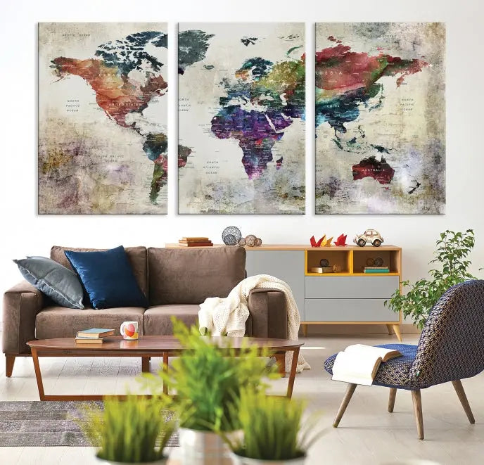 A living room featuring a triptych of the Watercolor World Map Wall Art Canvas Print.