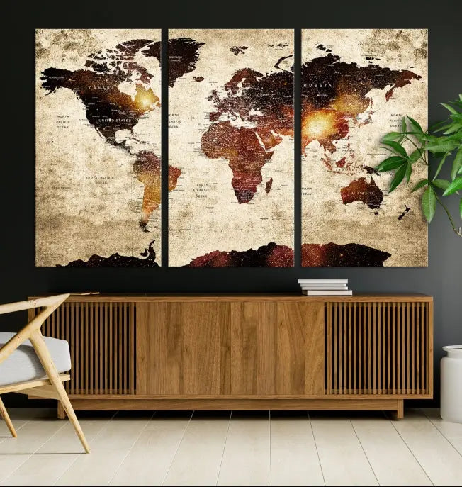 The Triptych of the Watercolor World Map Wall Art Canvas Print, featuring dark staining, is displayed on museum-quality canvas in a modern room.