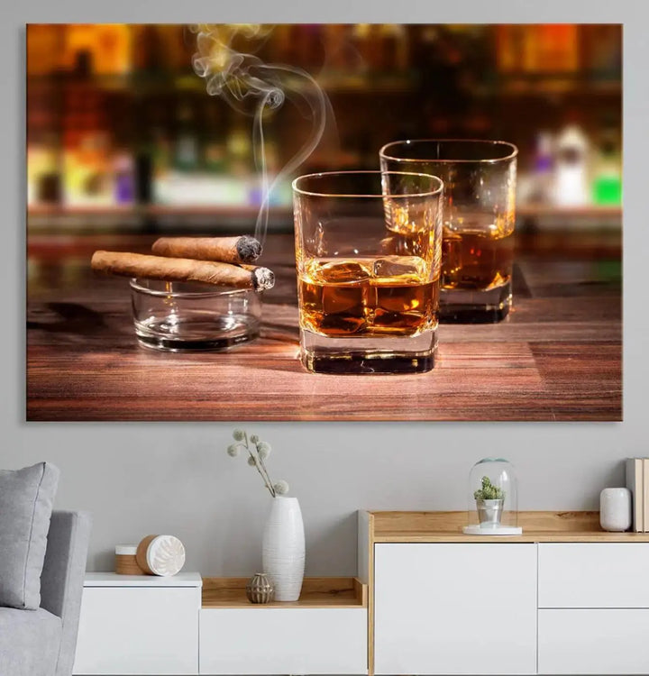 The Whiskey Cuban Cigars Canvas Print is a triptych wall art set that showcases two cigars and whiskey glasses on a wooden table. It is printed on museum-quality canvases with a UV-protective coating, designed for easy hanging.