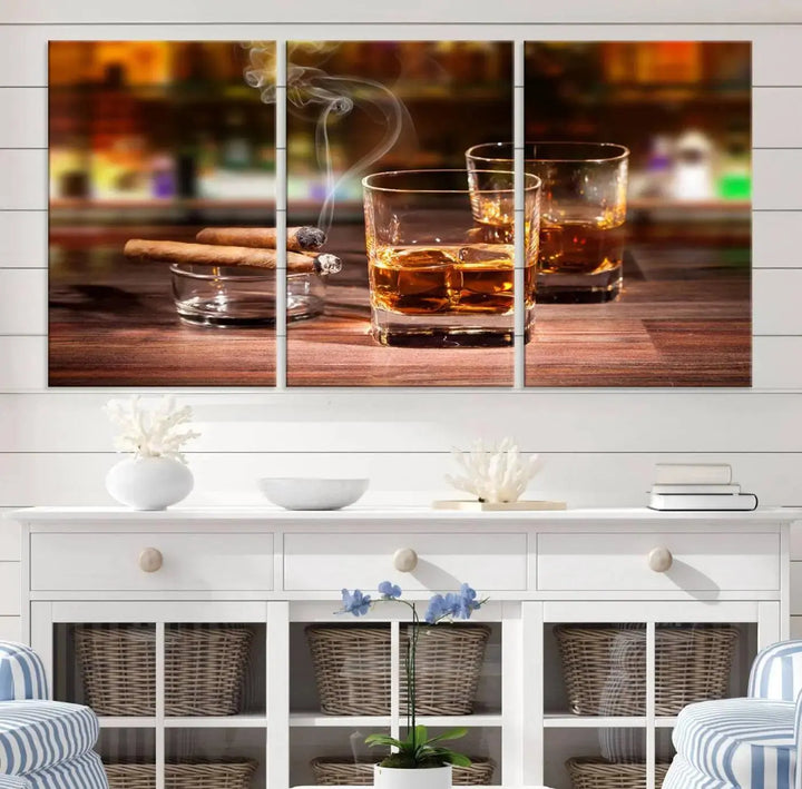 The Whiskey Cuban Cigars Canvas Print is a triptych wall art set that showcases two cigars and whiskey glasses on a wooden table. It is printed on museum-quality canvases with a UV-protective coating, designed for easy hanging.