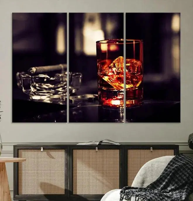 The Whiskey and Cigar Canvas, a luxurious triptych wall art for your living room or bar, portrays a whiskey glass and cigar on a table. This artwork beautifully captures the essence of opulent home decor.