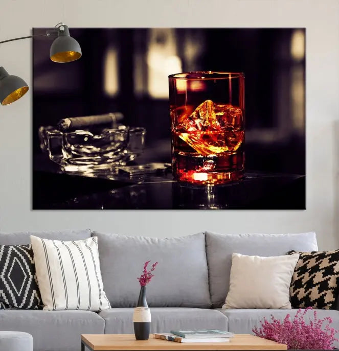 The Whiskey and Cigar Canvas, a luxurious triptych wall art for your living room or bar, portrays a whiskey glass and cigar on a table. This artwork beautifully captures the essence of opulent home decor.