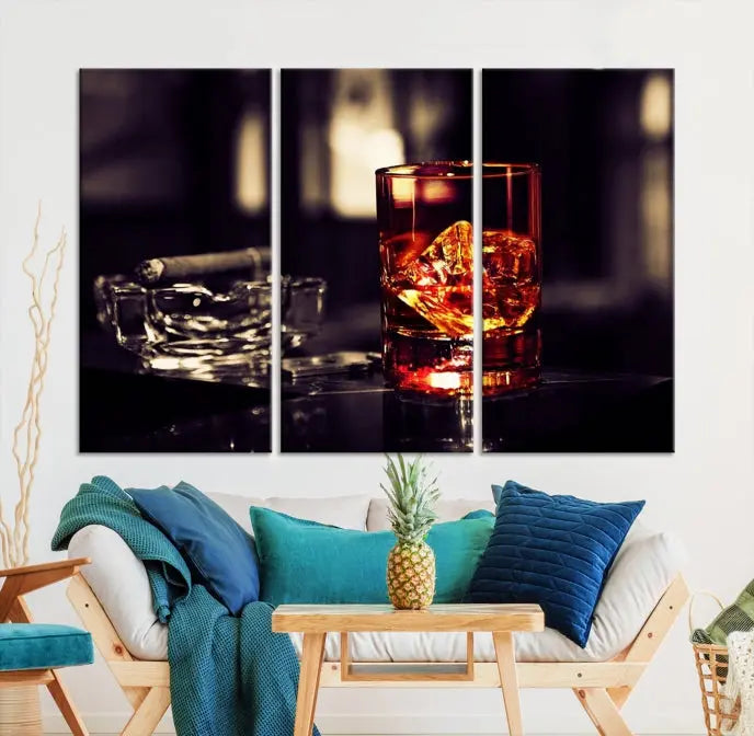 The Whiskey and Cigar Canvas, a luxurious triptych wall art for your living room or bar, portrays a whiskey glass and cigar on a table. This artwork beautifully captures the essence of opulent home decor.