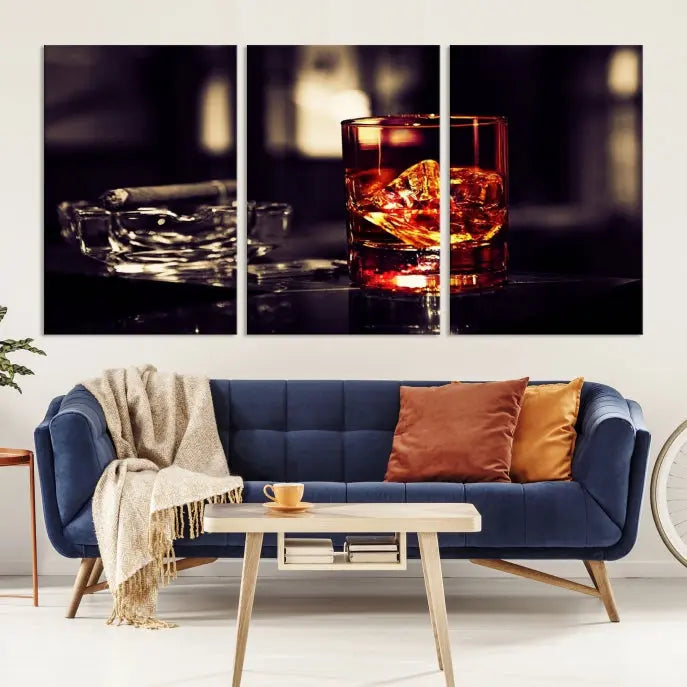 The Whiskey and Cigar Canvas, a luxurious triptych wall art for your living room or bar, portrays a whiskey glass and cigar on a table. This artwork beautifully captures the essence of opulent home decor.