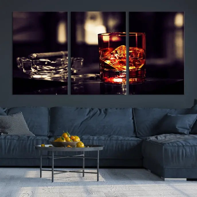 The Whiskey and Cigar Canvas, a luxurious triptych wall art for your living room or bar, portrays a whiskey glass and cigar on a table. This artwork beautifully captures the essence of opulent home decor.