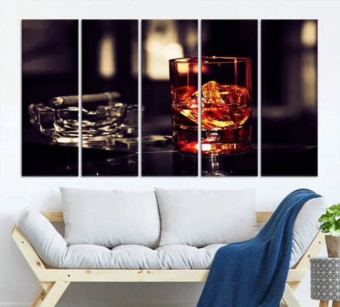 The Whiskey and Cigar Canvas, a luxurious triptych wall art for your living room or bar, portrays a whiskey glass and cigar on a table. This artwork beautifully captures the essence of opulent home decor.