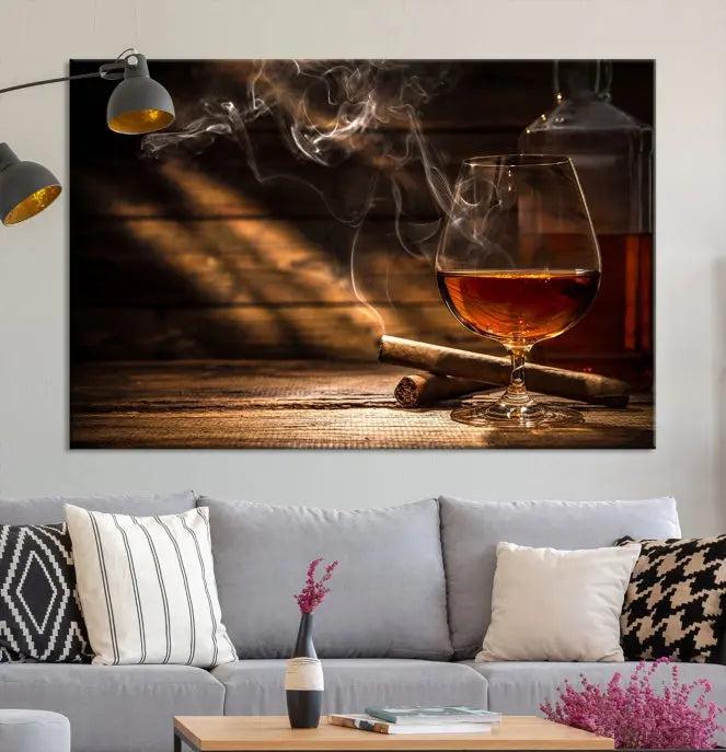 Whiskey and Cigar Wall Art Canvas Print showcases a glass of brandy, a lit cigar, and swirling smoke. This museum-quality canvas is ready to hang and features a UV-protective coating for enduring vibrancy.