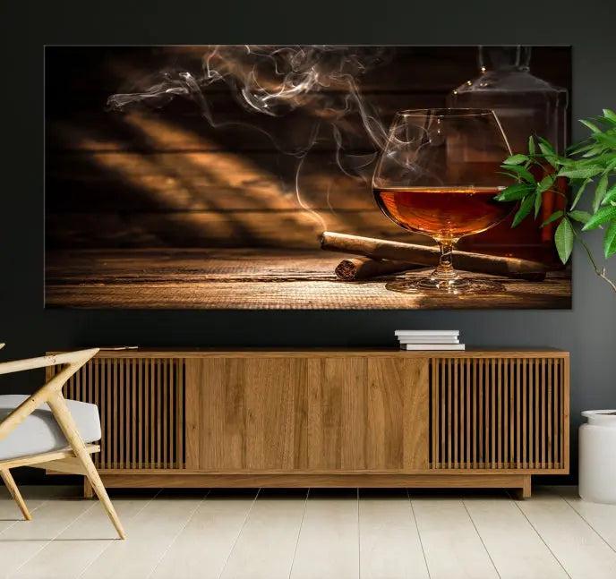 Whiskey and Cigar Wall Art Canvas Print showcases a glass of brandy, a lit cigar, and swirling smoke. This museum-quality canvas is ready to hang and features a UV-protective coating for enduring vibrancy.