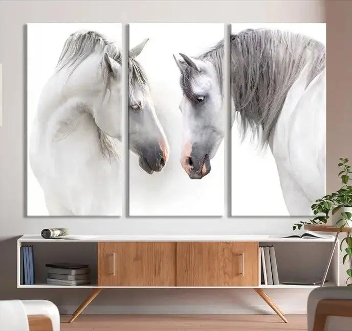 The "White Horse Wall Art Animal Canvas Print," featuring two white horses facing each other, is elegantly displayed. This triptych is gallery wrapped on museum-quality canvas, ensuring long-lasting beauty and sophistication.