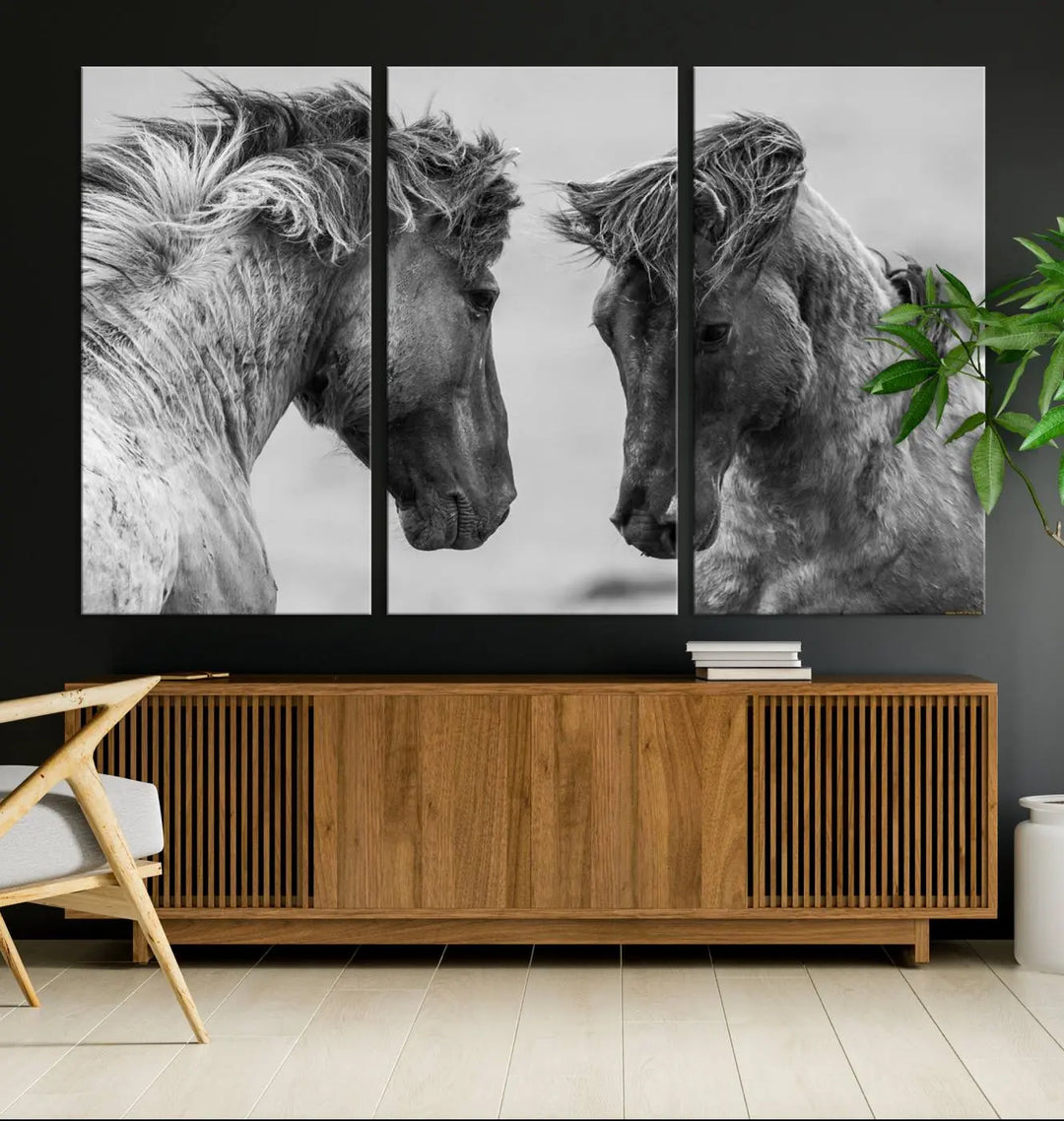 The "White Horses Wall Art Canvas Print" features a striking black and white triptych of two horses facing each other, perfect for display on a dark wall. Each piece is crafted on museum-quality poly-cotton canvas and meticulously hand-assembled, ensuring both elegance and long-lasting durability. Elevate your space effortlessly with free shipping included.