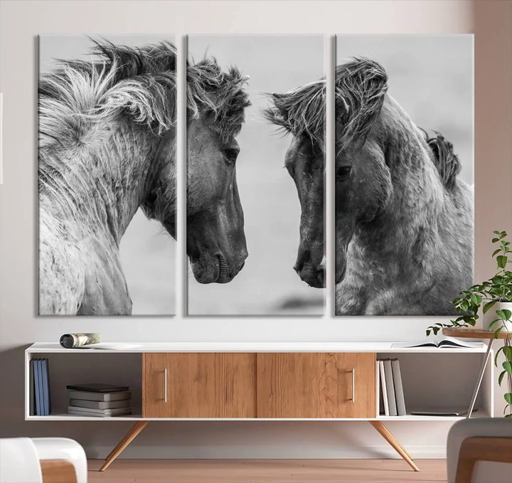 The "White Horses Wall Art Canvas Print" features a striking black and white triptych of two horses facing each other, perfect for display on a dark wall. Each piece is crafted on museum-quality poly-cotton canvas and meticulously hand-assembled, ensuring both elegance and long-lasting durability. Elevate your space effortlessly with free shipping included.