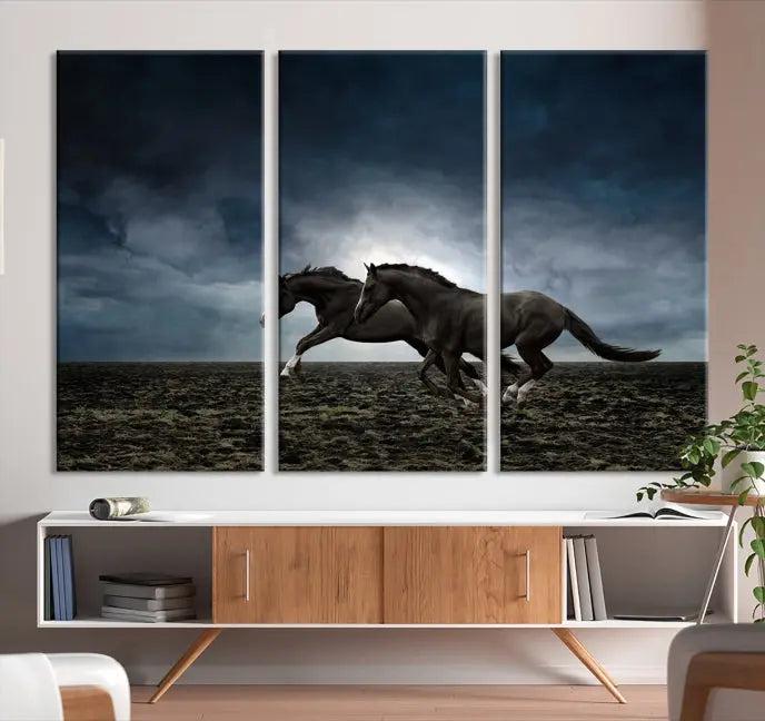 The Wild Horses Wall Art Canvas Print features a triptych of two galloping black horses set against a dark, cloudy landscape. This piece is gallery-wrapped on museum-quality canvas.