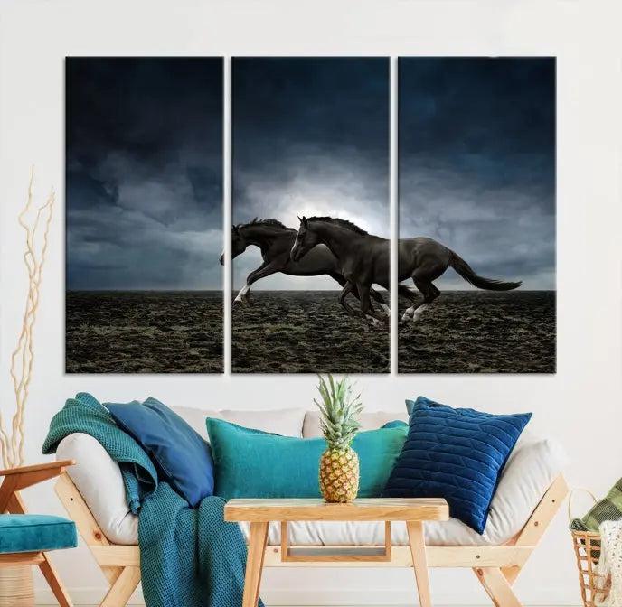 The Wild Horses Wall Art Canvas Print features a triptych of two galloping black horses set against a dark, cloudy landscape. This piece is gallery-wrapped on museum-quality canvas.