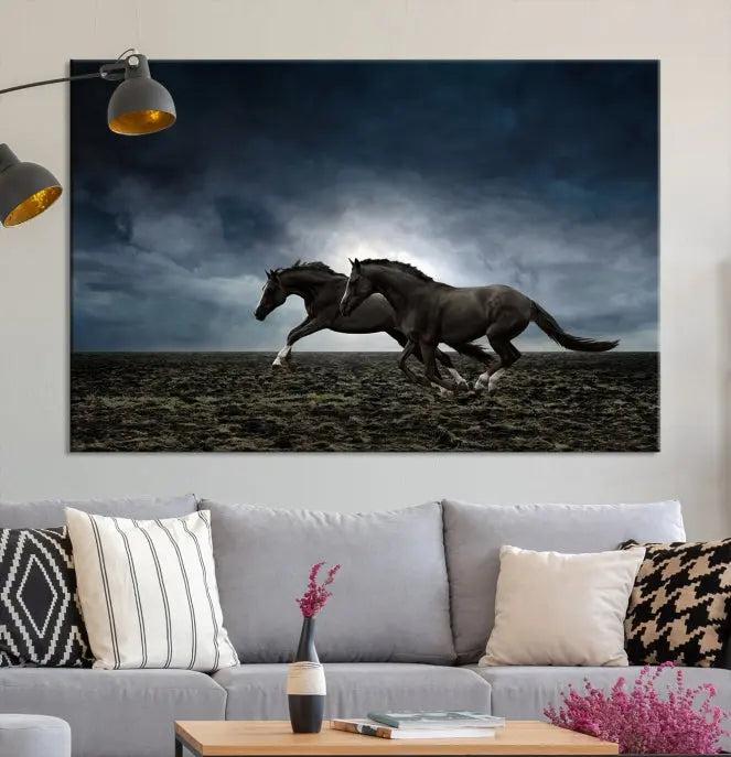 The Wild Horses Wall Art Canvas Print features a triptych of two galloping black horses set against a dark, cloudy landscape. This piece is gallery-wrapped on museum-quality canvas.