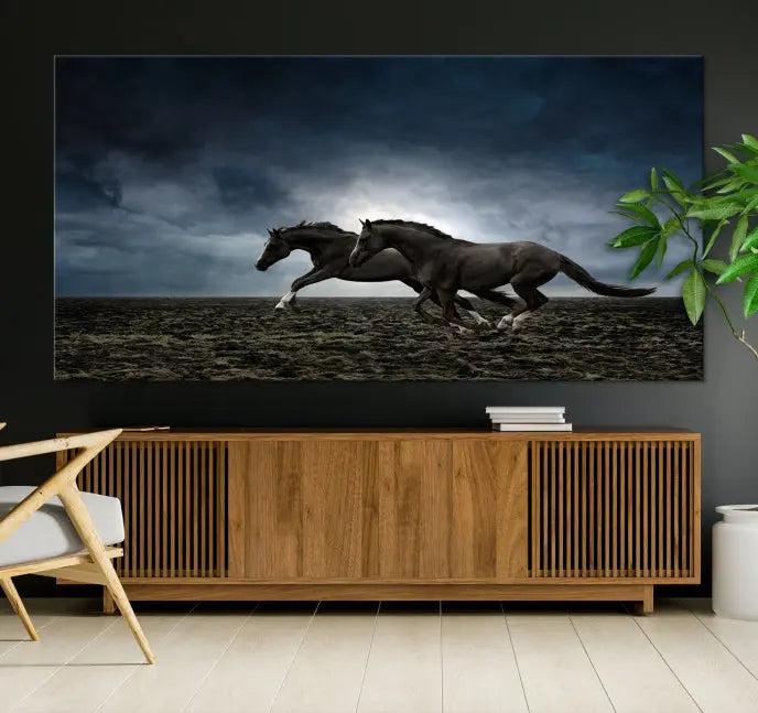 The Wild Horses Wall Art Canvas Print features a triptych of two galloping black horses set against a dark, cloudy landscape. This piece is gallery-wrapped on museum-quality canvas.