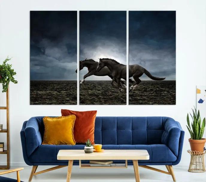 The Wild Horses Wall Art Canvas Print features a triptych of two galloping black horses set against a dark, cloudy landscape. This piece is gallery-wrapped on museum-quality canvas.