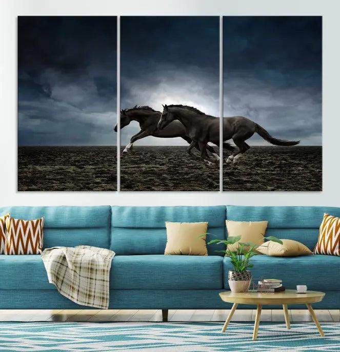 The Wild Horses Wall Art Canvas Print features a triptych of two galloping black horses set against a dark, cloudy landscape. This piece is gallery-wrapped on museum-quality canvas.