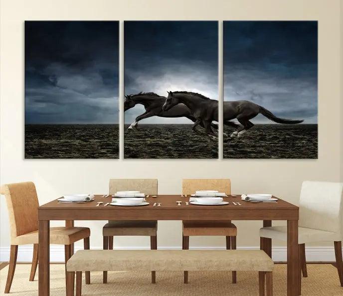 The Wild Horses Wall Art Canvas Print features a triptych of two galloping black horses set against a dark, cloudy landscape. This piece is gallery-wrapped on museum-quality canvas.