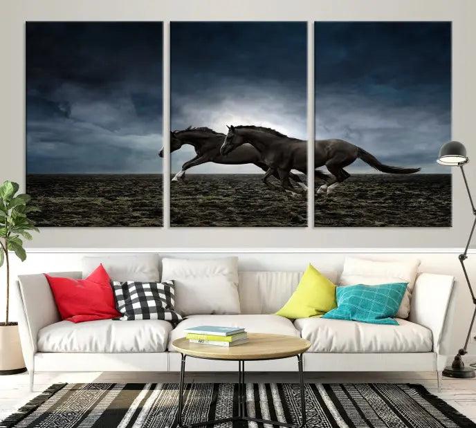 The Wild Horses Wall Art Canvas Print features a triptych of two galloping black horses set against a dark, cloudy landscape. This piece is gallery-wrapped on museum-quality canvas.