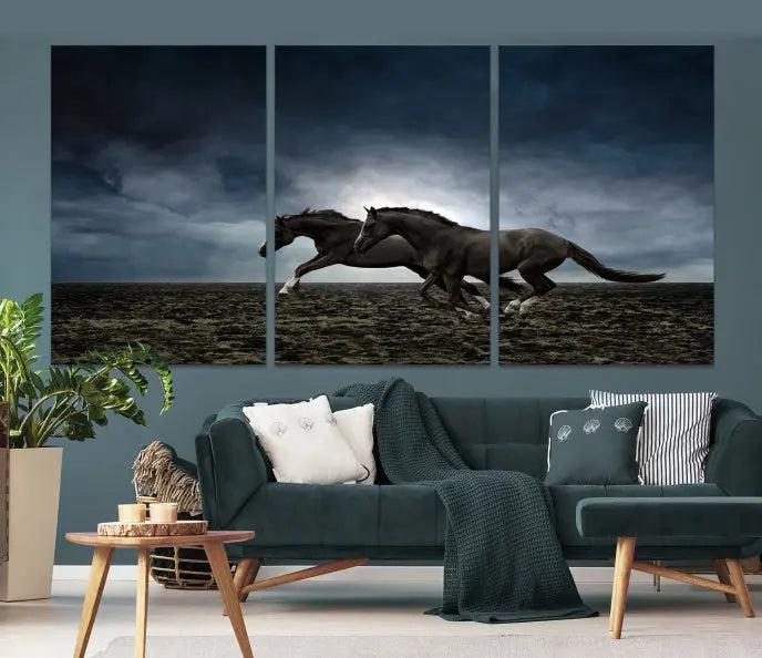 The Wild Horses Wall Art Canvas Print features a triptych of two galloping black horses set against a dark, cloudy landscape. This piece is gallery-wrapped on museum-quality canvas.