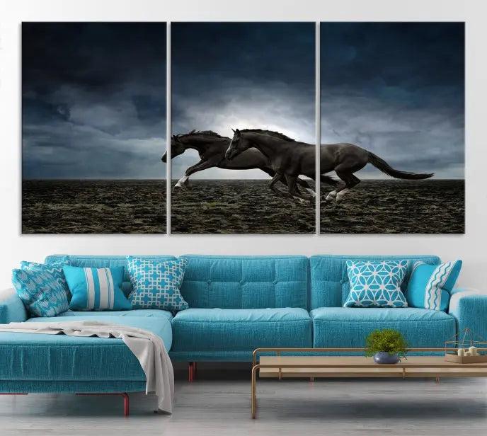 The Wild Horses Wall Art Canvas Print features a triptych of two galloping black horses set against a dark, cloudy landscape. This piece is gallery-wrapped on museum-quality canvas.