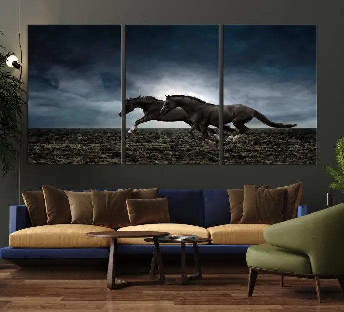 The Wild Horses Wall Art Canvas Print features a triptych of two galloping black horses set against a dark, cloudy landscape. This piece is gallery-wrapped on museum-quality canvas.