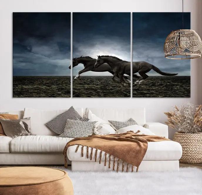 The Wild Horses Wall Art Canvas Print features a triptych of two galloping black horses set against a dark, cloudy landscape. This piece is gallery-wrapped on museum-quality canvas.